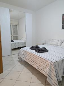 a white bedroom with a bed with a mirror at Il Centro Apartments 3 in Salsomaggiore Terme