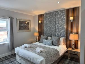 ein Schlafzimmer mit einem Bett, auf dem zwei Handtücher liegen in der Unterkunft Belstane Manor in Carluke