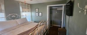 a bedroom with a bed and a flat screen tv at Barclay Cottage Inn in Virginia Beach