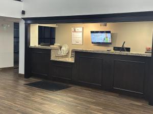 a lobby with a reception counter with a television at Red Roof Inn & Suites Middleborough in Middleboro