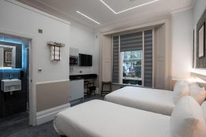 a hotel room with two beds and a desk at MSK The Whiteley in London