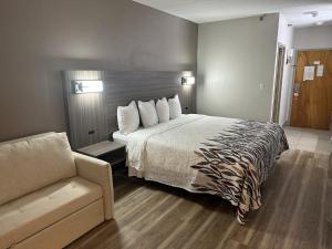 a hotel room with a bed and a couch at Red Roof Inn & Suites Middleborough in Middleboro +39 photos