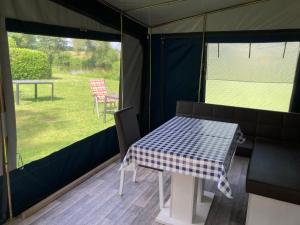 a tent with a table and chairs in it at Mietwohnwagen E2 am Flussufer in Wienhausen