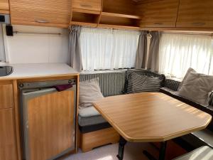 a living room with a table and a couch at Mietwohnwagen E2 am Flussufer in Wienhausen