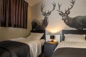 a bedroom with two beds with deer heads on the wall at Residence Winterswijk in Winterswijk +39 photos