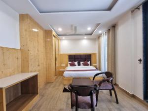 a bedroom with a bed and a desk and a chair at Nomad Uber Hotel - Near Mall Road Dalhousie in Dalhousie