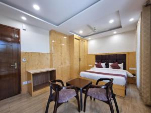 a bedroom with a bed and a table and chairs at Nomad Uber Hotel - Near Mall Road Dalhousie in Dalhousie