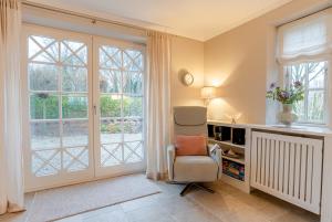 a living room with a chair and a window at Friesenliebe in Borgsum