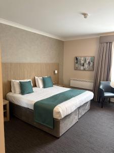 a hotel room with a large bed and a chair at The Park Hotel in Kilmarnock