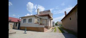 a small white house with a chimney on a street at Pension Paradise Slowakia in Pastovce