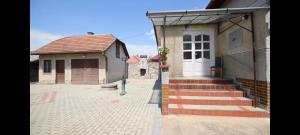 a small house with a white door and some stairs at Pension Paradise Slowakia in Pastovce