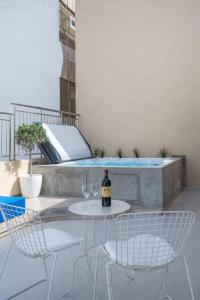 a patio with a table and chairs and a swimming pool at Notos Boutique Apartments 3 with Private Jacuzzi in Heraklio
