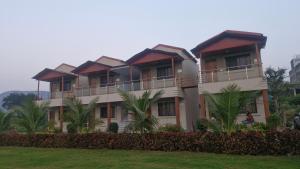 a building with palm trees in front of it at Shri Balaji Resort in Ellora