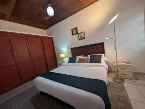 a bedroom with a large bed with a wooden headboard at Baobab Lodge Douala - Makepe in Douala