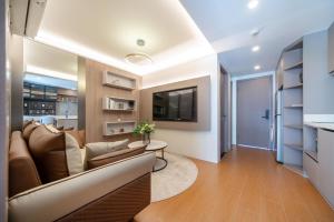 a living room with a couch and a tv at Capri Residence Bangtao in Bang Tao Beach