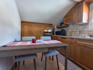 a kitchen with a wooden table and chairs in it at Ferienwohnung mit Herz in Schwyz +8 photos