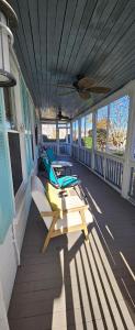 a porch with chairs and surfboards on a house at Barclay Cottage Inn in Virginia Beach