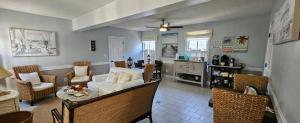 a living room with a white couch and chairs at Barclay Cottage Inn in Virginia Beach