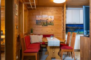 a dining room with a table and red chairs at Apartment Dijak in Bohinj