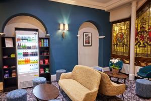 a waiting room with a chair and a drink machine at Thistle London Bloomsbury Park in London +26 photos