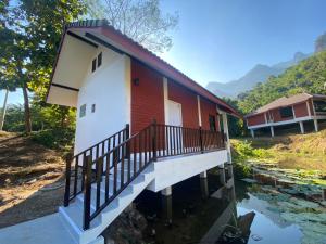 a house with a balcony on a body of water at Saen Kam Resort in Ban Tham