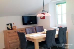 a dining room table with chairs and a tv at Fitzlhof in Sankt Koloman