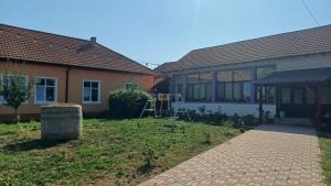 a house with a brick walkway in front of it at Casa Pelerinului in Bogata