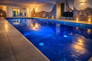 ein Swimmingpool mit blauem Wasser in einem Haus in der Unterkunft Dixon Resort & Wellness in Banská Bystrica