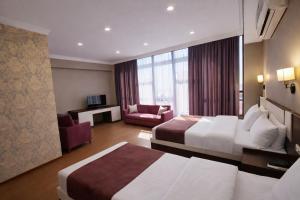 a hotel room with two beds and a living room at Cherry Garden Boutique Hotel in Yeghegnadzor