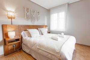 a bedroom with a large bed with two towels on it at Habitaciones Guriezo in El Puente