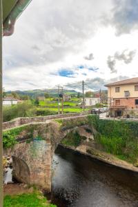 an old stone bridge over a river at Habitaciones Guriezo in El Puente
