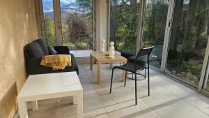 a living room with a couch and chairs and windows at Villa Berninoise in Bernin