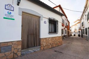 a building with a wooden door on a street at Antonia Medina Relax in Cogollos de Guadix