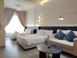 a hotel room with two beds and a couch at Sunsuria Forum Soho by Diamond in Shah Alam +24 photos