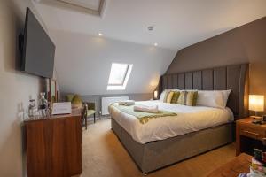 a bedroom with a large bed with a wooden headboard at The Redesdale in Moreton in Marsh +79 photos