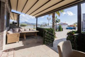 a patio with a couch and a table at Adonis Resort & Spa in Egina