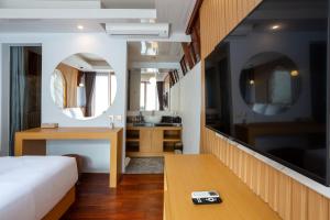 a hotel room with a bed and a mirror at Merta Luwih Villa in Tanah Lot
