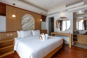 a bedroom with a large white bed and a kitchen at Merta Luwih Villa in Tanah Lot +24 photos