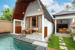 a villa with a pool and a bedroom at Merta Luwih Villa in Tanah Lot