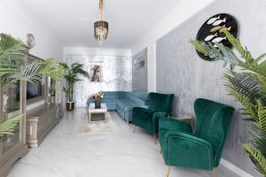 a living room with a blue couch and green chairs at Adonis Resort & Spa in Egina