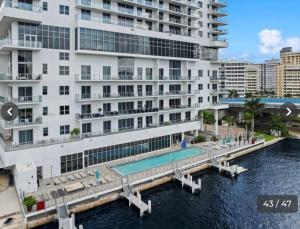 a large building with a swimming pool next to a body of water at Hyde house 3507 AL MAR in Hollywood