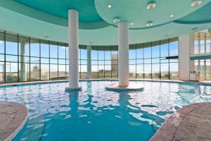 a swimming pool in a building with large windows at Turquoise Place Beachside Retreat in Orange Beach