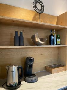 a kitchen counter with a coffee maker and bottles of wine at New and elegant luxury apartment in Kloten