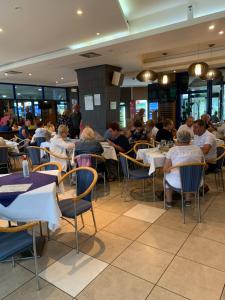 a group of people sitting at tables in a restaurant at Motel Aleksandar in Pojate