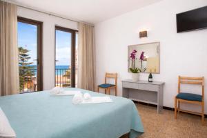 a hotel room with a bed and a view of the ocean at Hotel OCTOPUS in Can Picafort