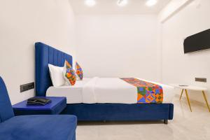 a bedroom with a blue and white bed and a table at FabHotel Saraca Inn in Indore +31 photos