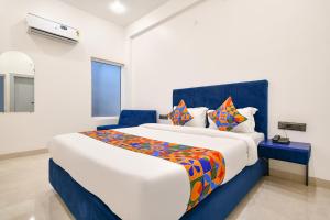 a bedroom with a large bed with colorful pillows at FabHotel Saraca Inn in Indore