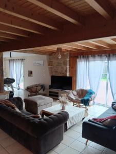 a living room with couches and a flat screen tv at Le gîte Le Marillet in Thorigny