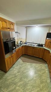 a large kitchen with wooden cabinets and a sink at Cozy Quiet Beach room R2 in Brighton +9 photos