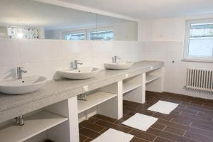 a bathroom with two sinks and two mirrors at Pension am Heckenacker in Rothenburg ob der Tauber
